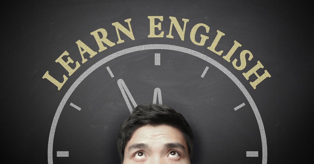 The language learning concept of Time To Learn English for English Education. Cropped image of a man's head looking up with a chalkboard behind him showing part of a clock and the words "Learn English"