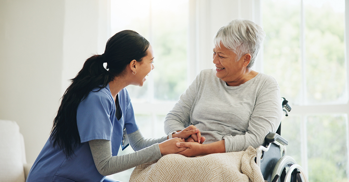 Female nurse providing care for Hispanic female patient in wheelchair