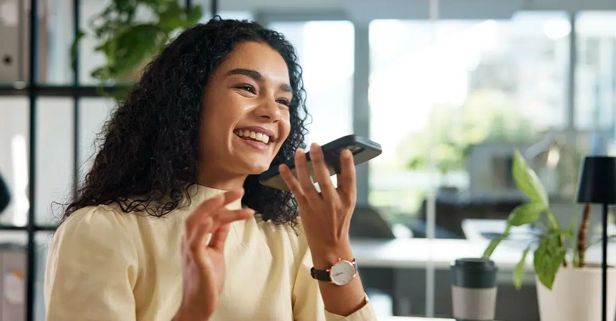 Female professional using voice recorder on her phone, illustrating the blog topic How to Practice Your Speaking Skills for Business by Yourself