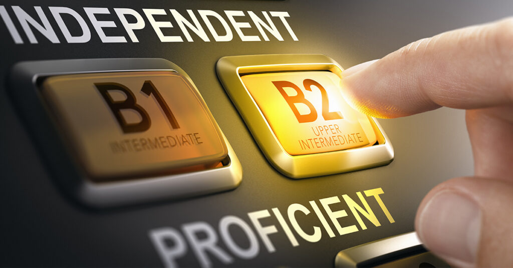 Man pushing button with the text B2 upper intermediate. Concept of language proficiency levels and international strandards CEFR. Composite image between a hand photography and a 3D background.