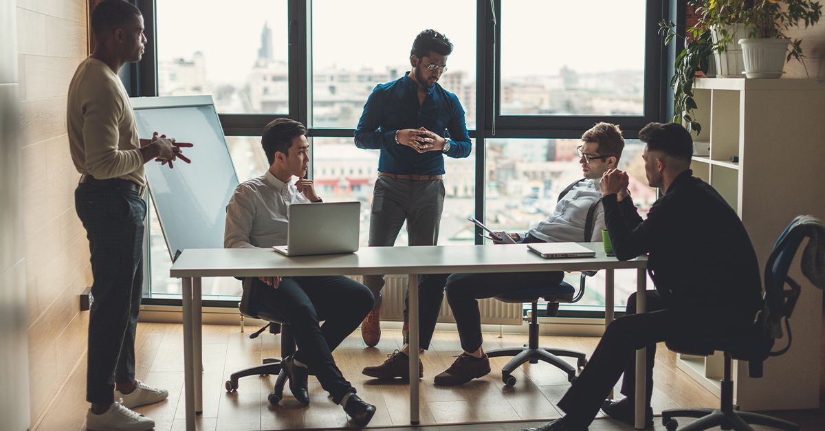 Multiracial staff of international company communicating in a modern loft office with panoramic view | The Role of Language Proficiency in International Leadership Development