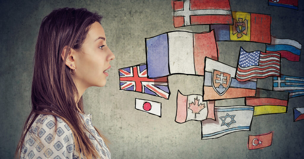 Young woman's profile against an illustrated background of many different countries' flags, illustrating the blog concept How to Say Business in 25 Different Languages