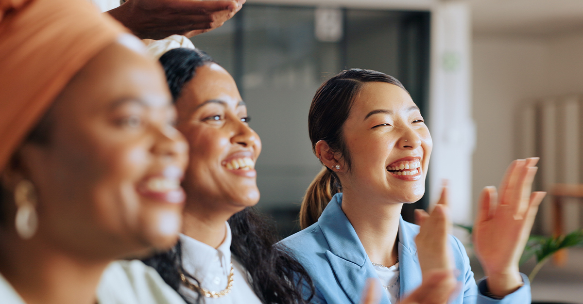 Expats in the workforce applauding at a corporate meeting