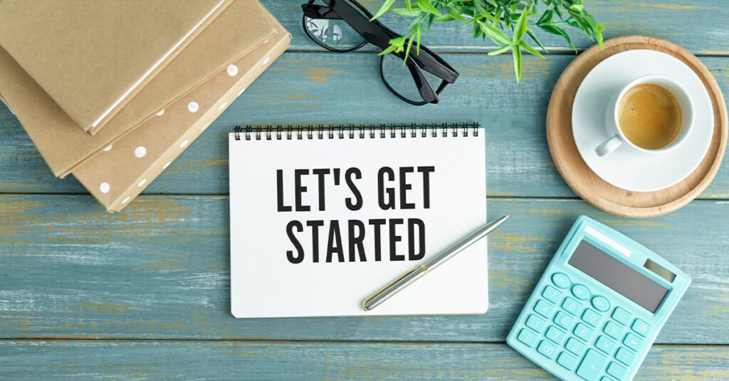 LET'S GET STARTED text concept write on notebook with office tools on a blue wooden background, illustrating the blog topic of Different Ways of Saying the English Phrase “Let’s Get Started” at the Workplace