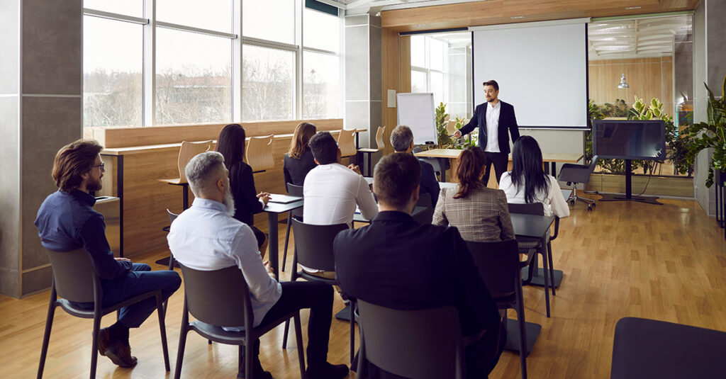 Group of professionals in a classroom setting, illustrating the blog topic 7 Reasons Why Your Workforce Isn’t Interested in the Language Classes You Offer Them