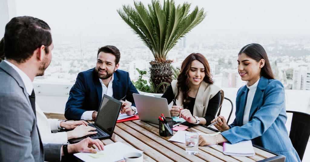 Group of young business people in meeting using laptop on terrace office working in Mexico