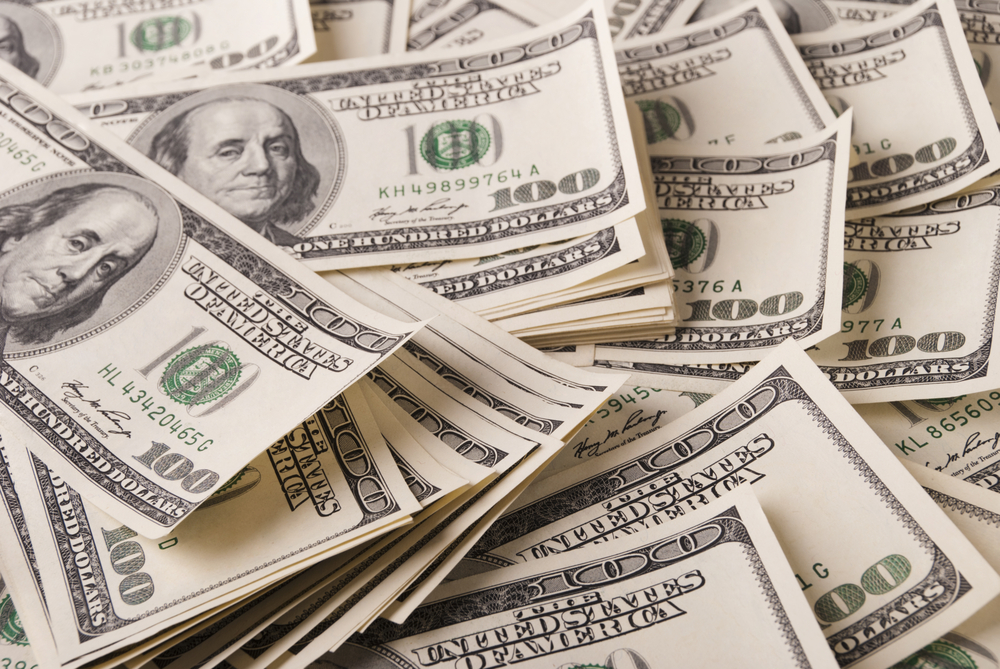 pile of hundred dollar bills used to symbolize the cost savings of corporate language training